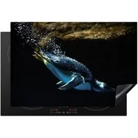 MuchoWow Herd-Abdeckplatte Ein Pinguin schwimmt im dunklen Wasser, Vinyl, (1 tlg), Induktionsabdeckung Vinyl, Küchenzubehör, 77x51 cm